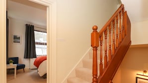 A staircase with wooden balusters and a carpeted landing. - Holme Rigg (Keswick)