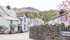 A stone wall with a sign pointing to Newland. - Holme Rigg (Keswick)