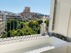 A balcony with a metal railing overlooking a cityscape, including a prominent historical building in the distance. - Diamond Suite Luxury Penthouse (Granada)