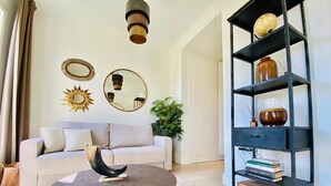 A living room with a white sofa, a round coffee table, a black bookshelf, and decorative mirrors on the wall. - Diamond Suite Luxury Penthouse (Granada)