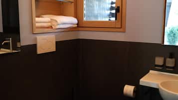 A modern bathroom with a toilet, bidet, and sink.