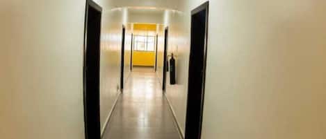 En lång, smal hall med ett klinkergolv och enkla väggar.