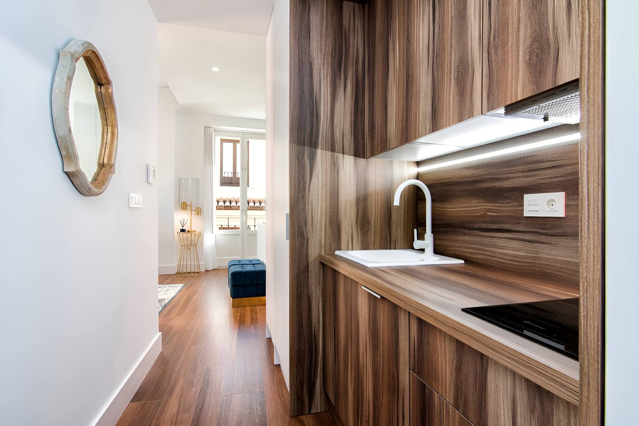 Een moderne keuken met houten kastjes, een wit spoelgedeelte en een inbouwoven.