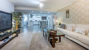 Un salon moderne avec un téléviseur à écran plat, une table basse et un canapé.