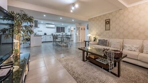 Un salon spacieux comprenant un grand canapé, une table basse et un coin repas avec une table et des chaises.
