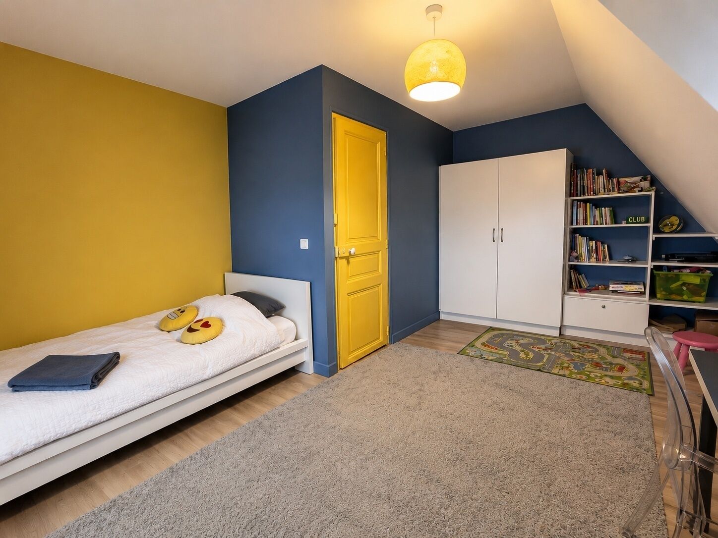 Une chambre à coucher avec un lit, une armoire, une bibliothèque et une porte.