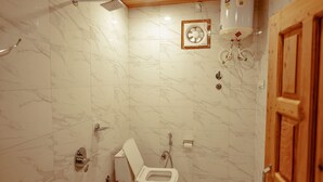 Une salle de bain équipée d’une douche, de toilettes et d’un chauffe-eau.