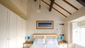 Una camera da letto con un letto, due comodini, un tavolino e un quadro appeso al muro.