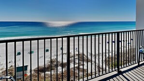 Ein Balkon mit Blick auf Strand und Meer.