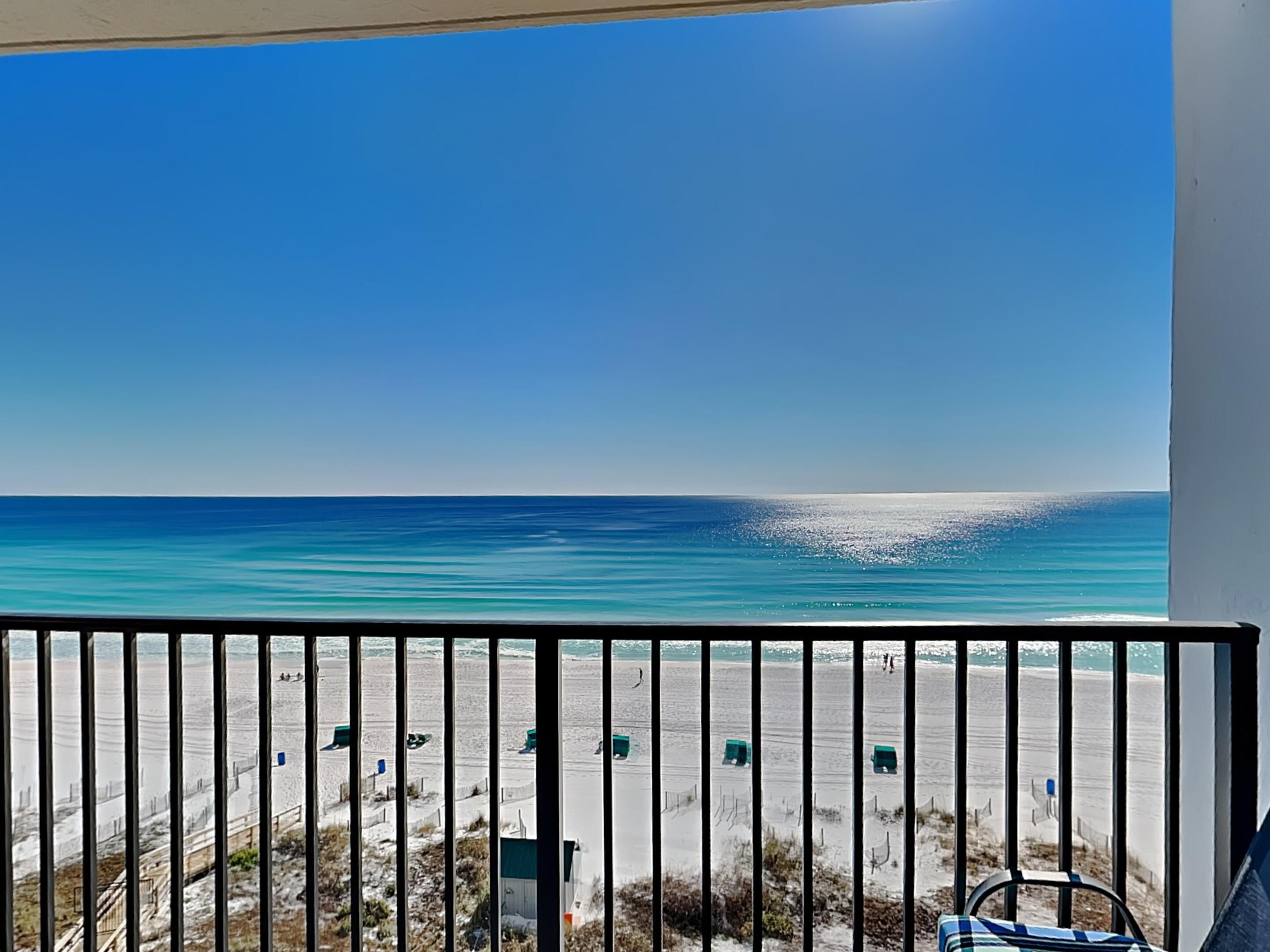 A balcony with a view of a beach and ocean.
