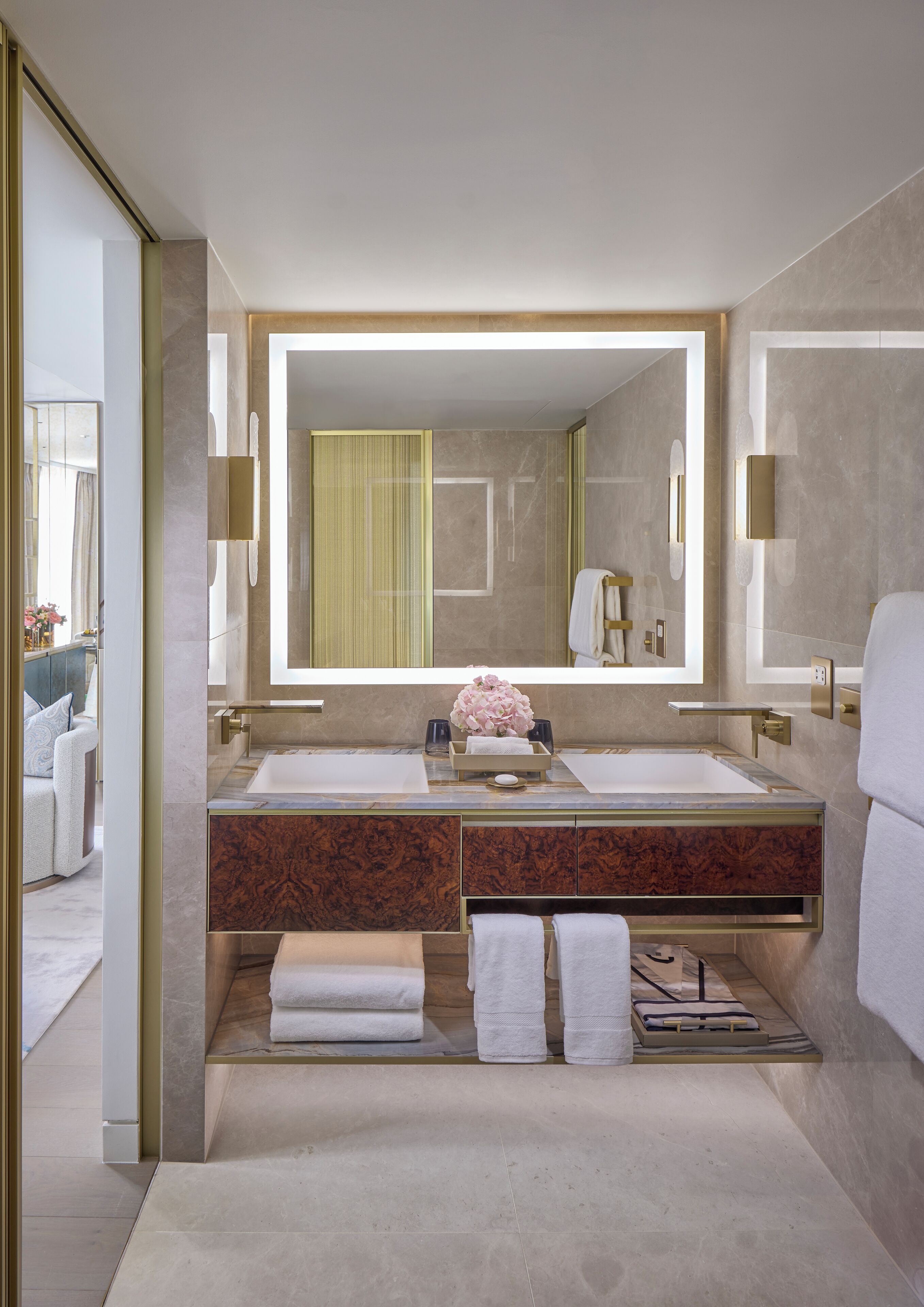 Un baño moderno con lavamanos dobles, un espejo grande y un tocador con encimera de mármol.