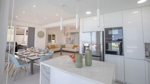 A modern kitchen with white cabinets, a marble countertop, and stainless steel appliances. - Villa Roxy, Fantastic 3BDR Seafront Protaras Villa with Pool (Protaras)