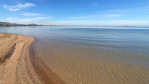 A beach with clear water, a sandy shore, and distant mountains. - Playa Paraíso apartment with lovely Mar Menor views (Playa Paraiso)