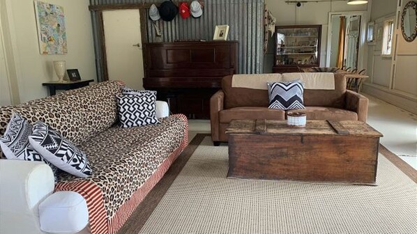 A living room with a sofa, a coffee table, and a television.
