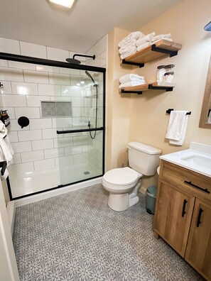 Ein modernes Badezimmer mit einer Duschkabine, einer Toilette und einem Waschbecken mit Holzausstattung.
