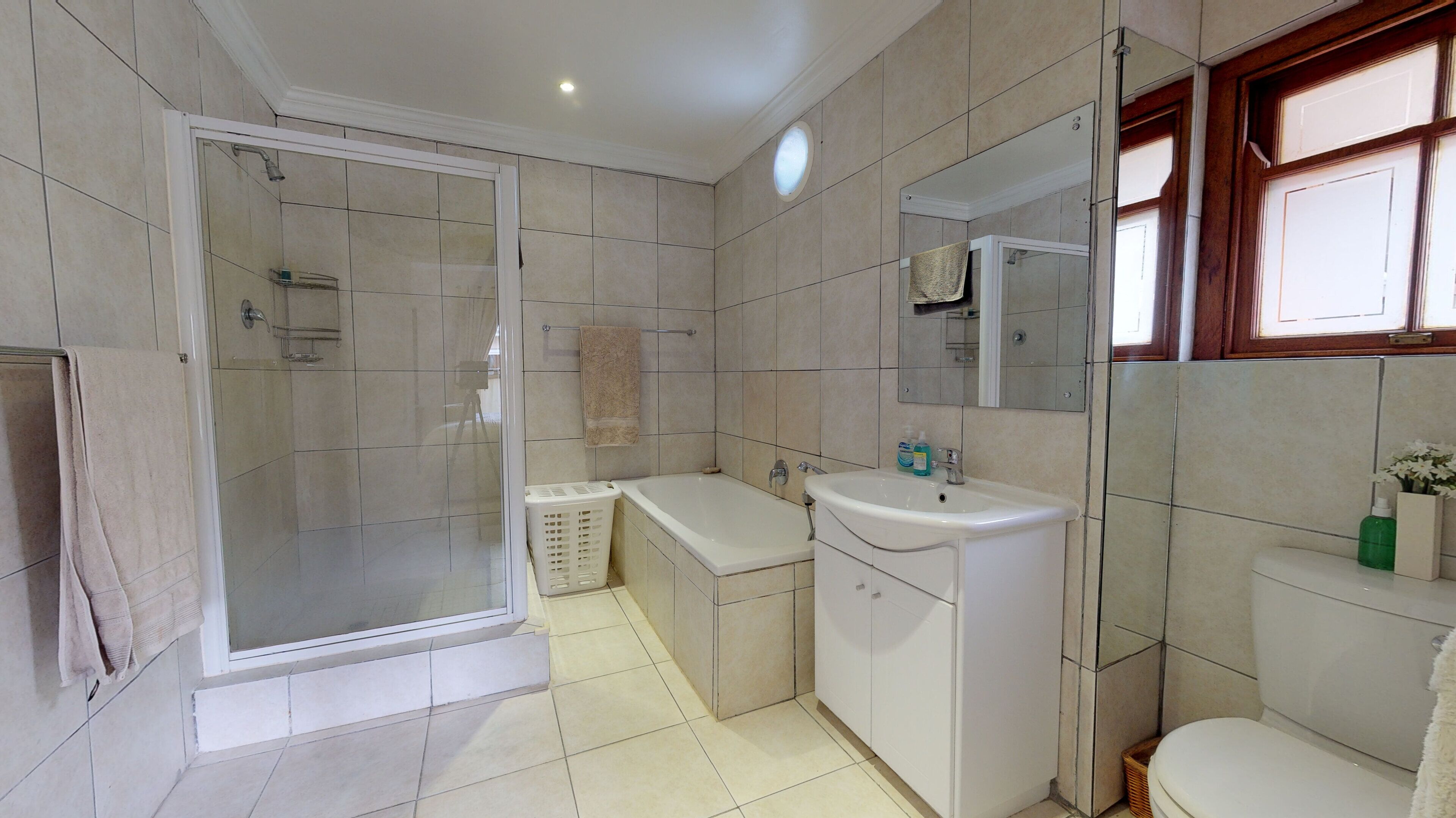 Een badkamer met douche, bad, toilet en wastafel.