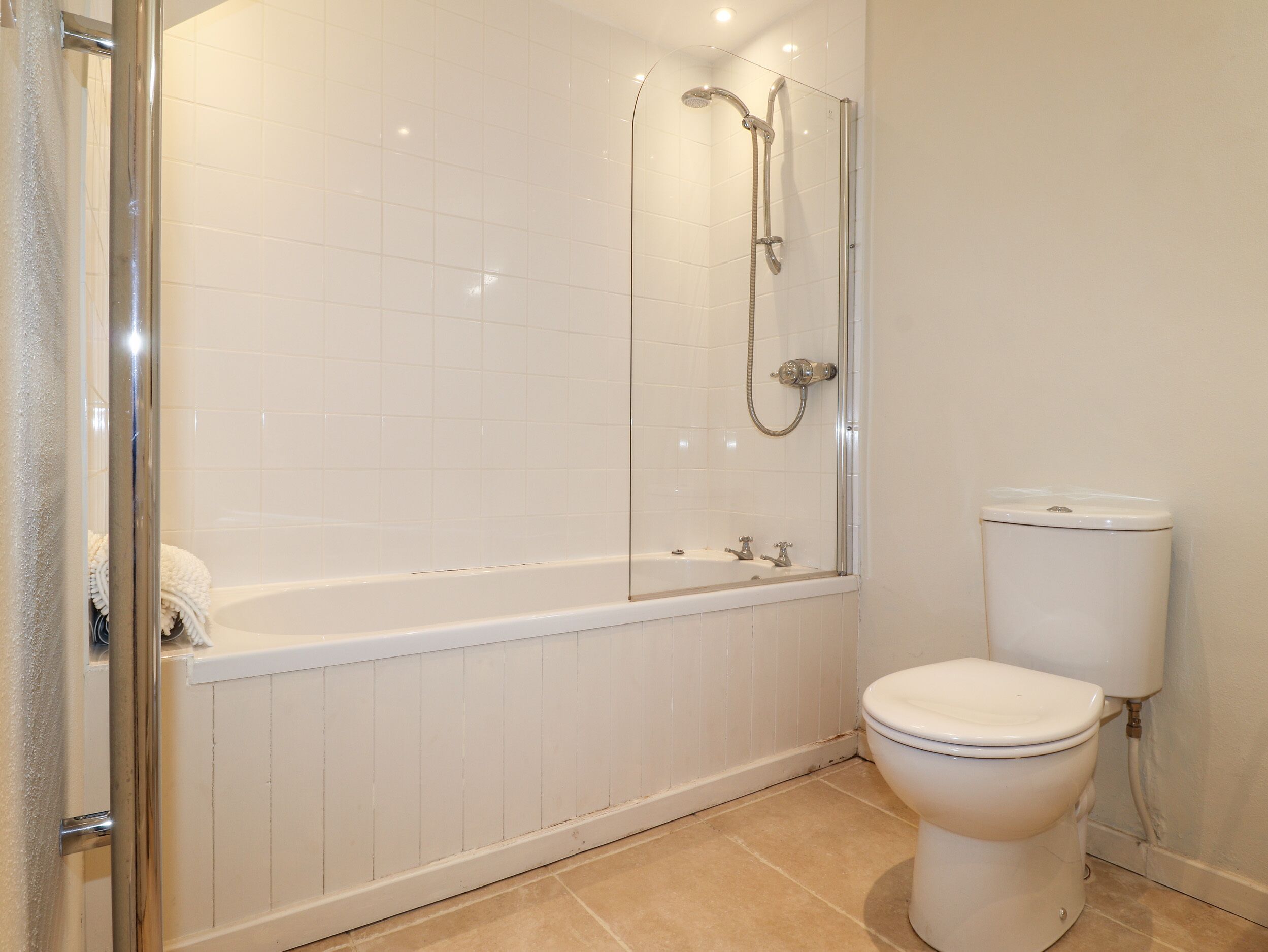 A bathroom with a shower, a bathtub, and a toilet.