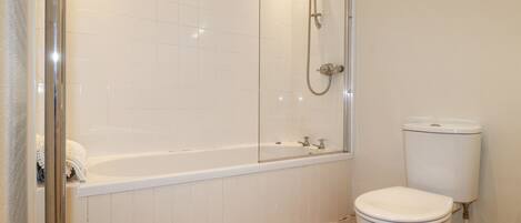 A bathroom with a shower, a bathtub, and a toilet.