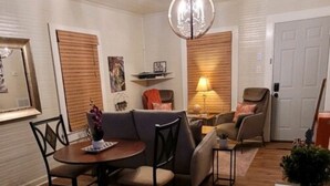 A cozy living room with a dining table, sofas, and a chandelier. - Clemson Memorabilia House (Clemson)