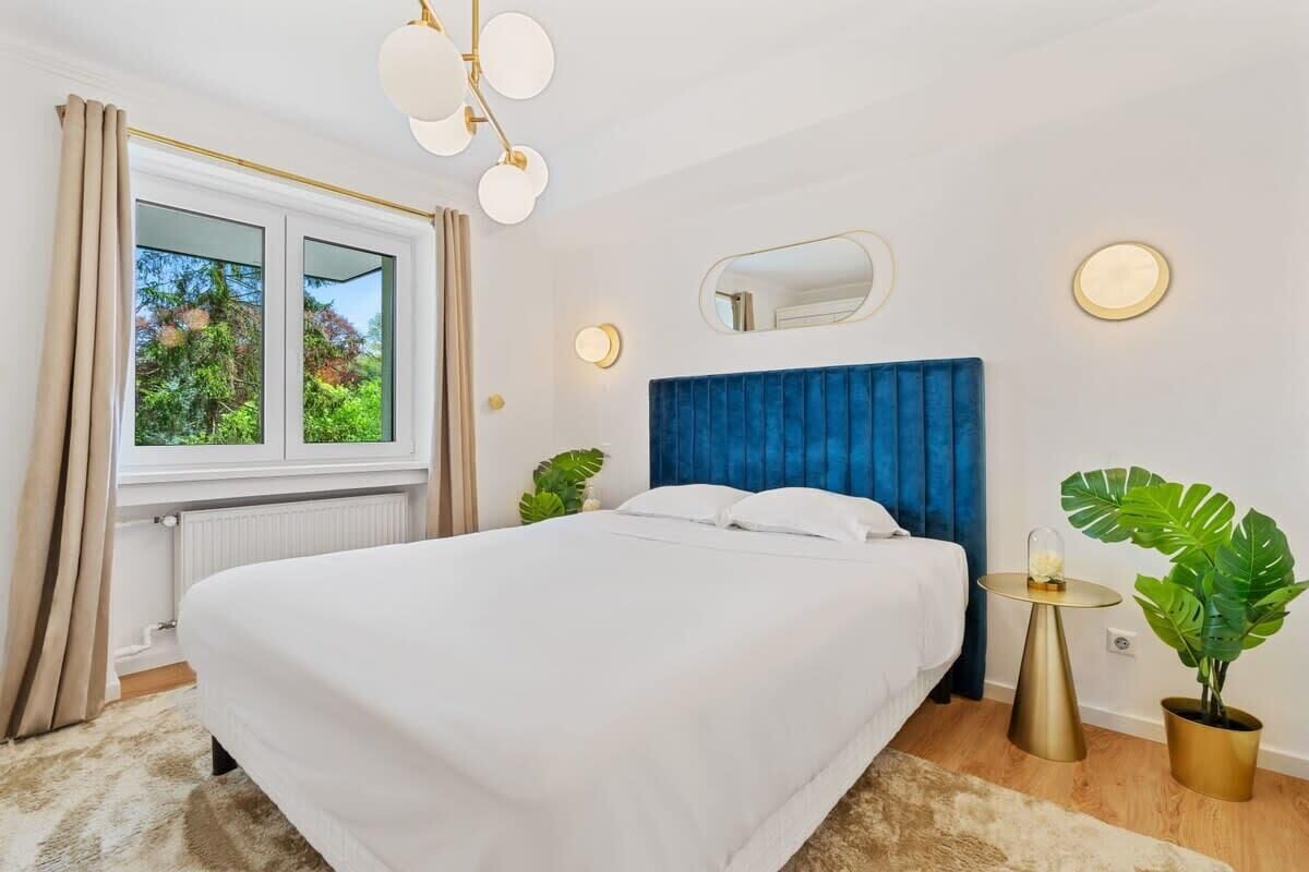 Elegant bedroom with a vibrant headboard and plenty of natural light.