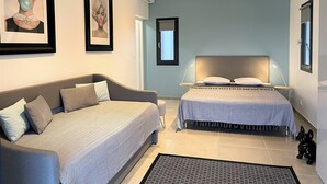 Un dormitorio moderno con un sofá, una cama y una pequeña estatua de perro.