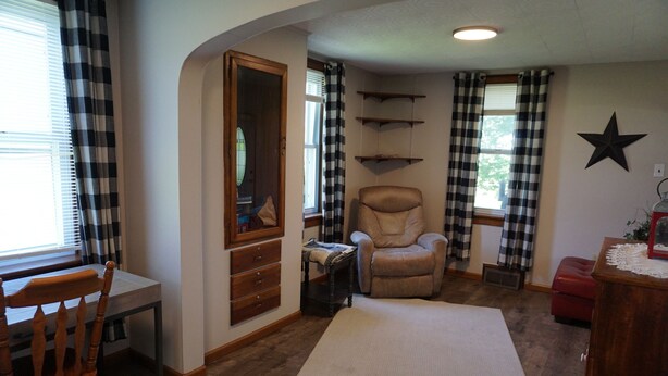 A room with a wooden chair, a desk, a large mirror, a rocking chair, and a star decoration on the wall. - Cozy Farm house 1950's Era but with modern updates (New Enterprise)