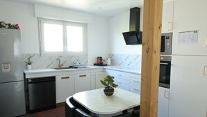 A modern kitchen with white cabinetry, a built-in oven, a microwave, and a dishwasher.
