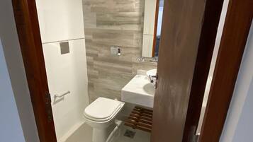 A bathroom with a toilet, sink, and shower.