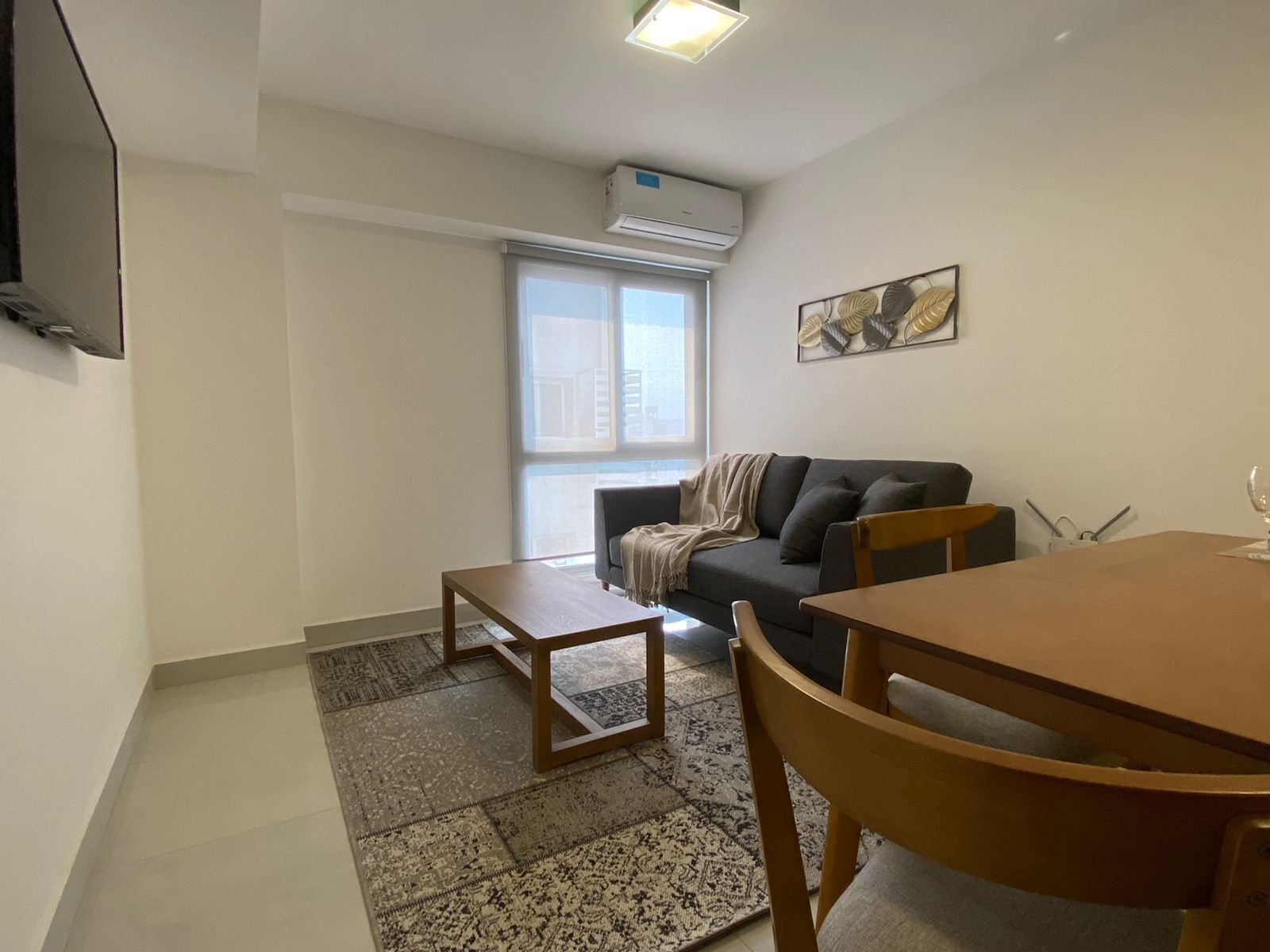A modern living room with a sofa, a coffee table, and a dining table.