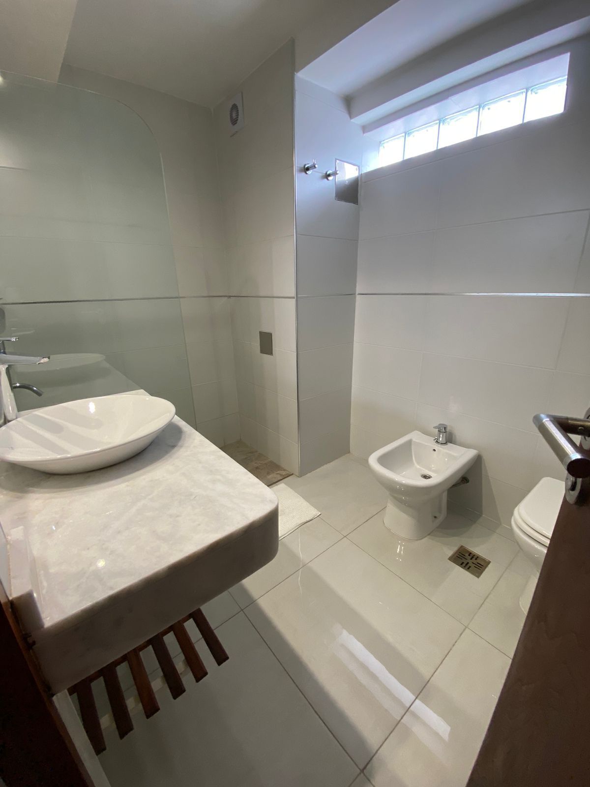 Un baño moderno con lavamanos grande, bidé y retrete.