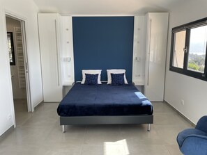 A modern bedroom with a bed, two pillows, a window, and a door. - Villa with sea view and heated infinity pool (Porto-Vecchio)