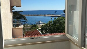 En balkon med havudsigt, et lille bord og en stol.