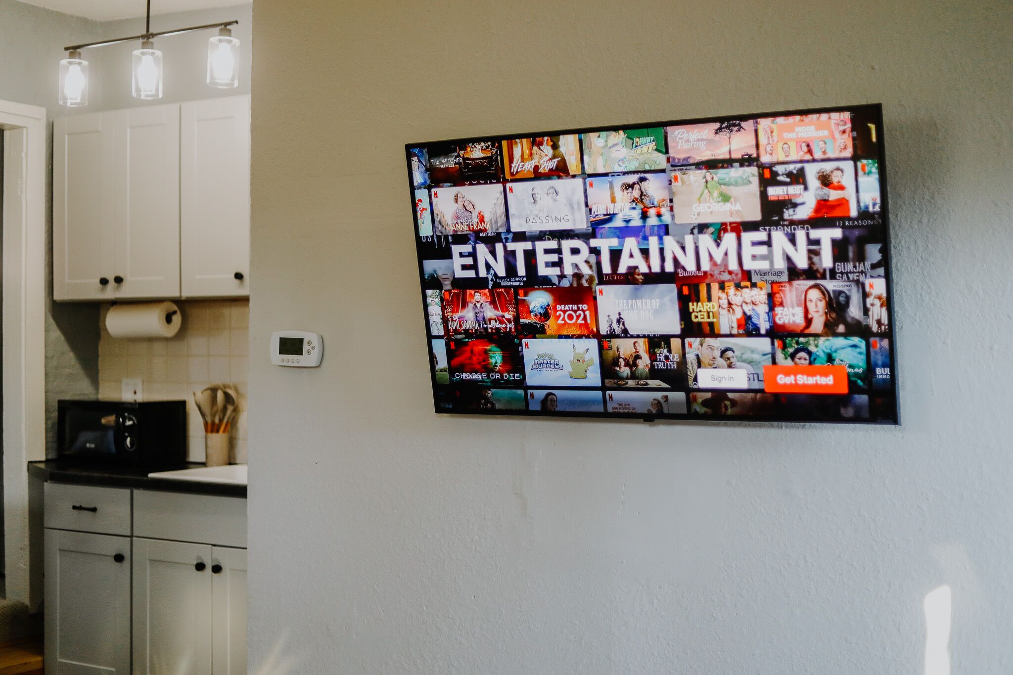 A wall-mounted screen displaying a grid of movie and TV show posters with the word "ENTERTAINMENT" prominently displayed.