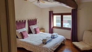 A bedroom with a bed, a chair, a window, and a ceiling fan. - 3 Peaceful Country Gites - Sleeps 16 with 2 Wood-Fired Hot Tubs & Swimming Pool (Melle)