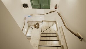 A staircase with a rustic design, including a wooden handrail and a decorative wreath at the bottom. - A Stare [Stone Apartment - Historic Center - Molfetta] (Molfetta)