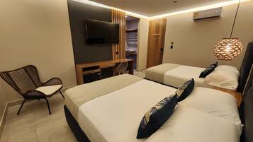 Una habitación de hotel con dos camas, televisión, una silla y un armario.