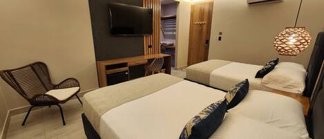 Een hotelkamer met twee bedden, een televisie, een stoel en een kledingkast.