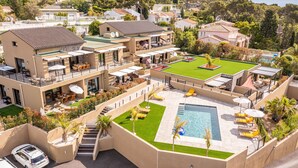 A modern multi-story building with a rooftop pool, outdoor seating, and a well-maintained lawn. - Apartment 2: Cap Lardier (Roquebrune-sur-Argens)