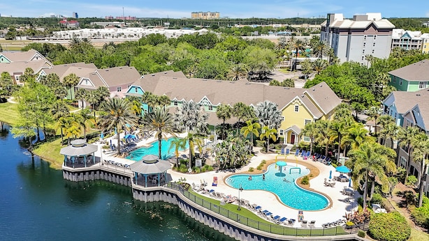 A resort with a large swimming pool, a dock, and a view of the surrounding area. - Key West Vibe & Disney Thrills: Tropical Condo w/ Water Park (KIssimmee)