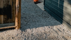 Una valla de madera con un letrero de Texaco, un espacio cubierto con techo de madera, y una calabaza al fondo.