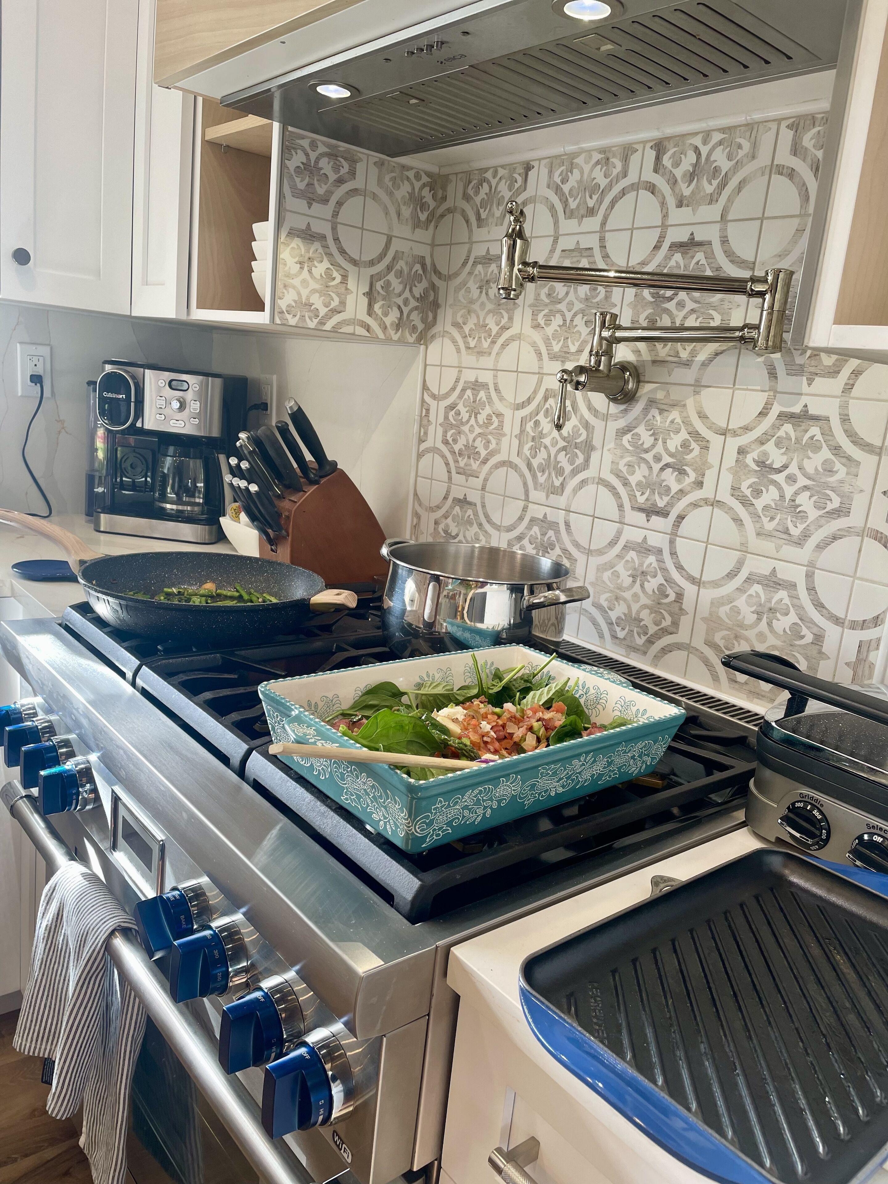 Une cuisine équipée d’une cuisinière à gaz, d’une machine à café et d’un crédence décorative.