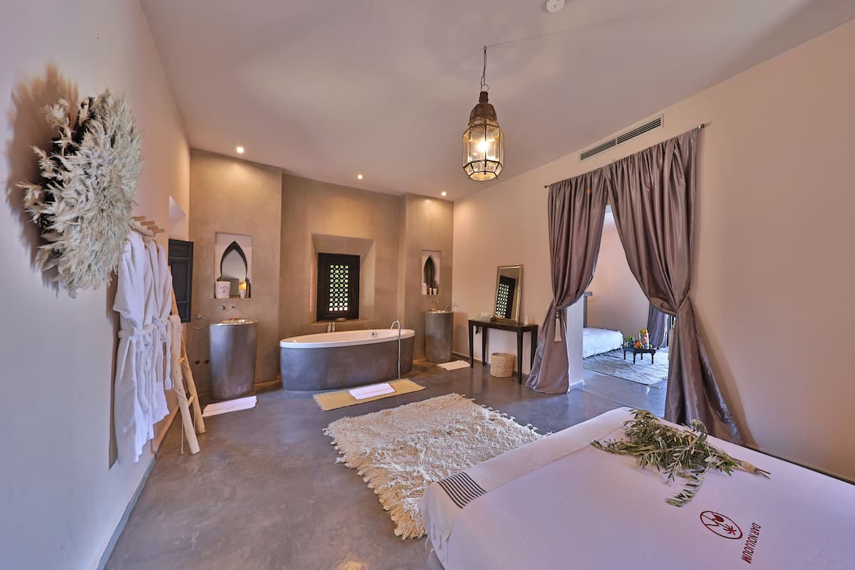 A modern bathroom with a freestanding bathtub, a large mirror, and a towel rack.