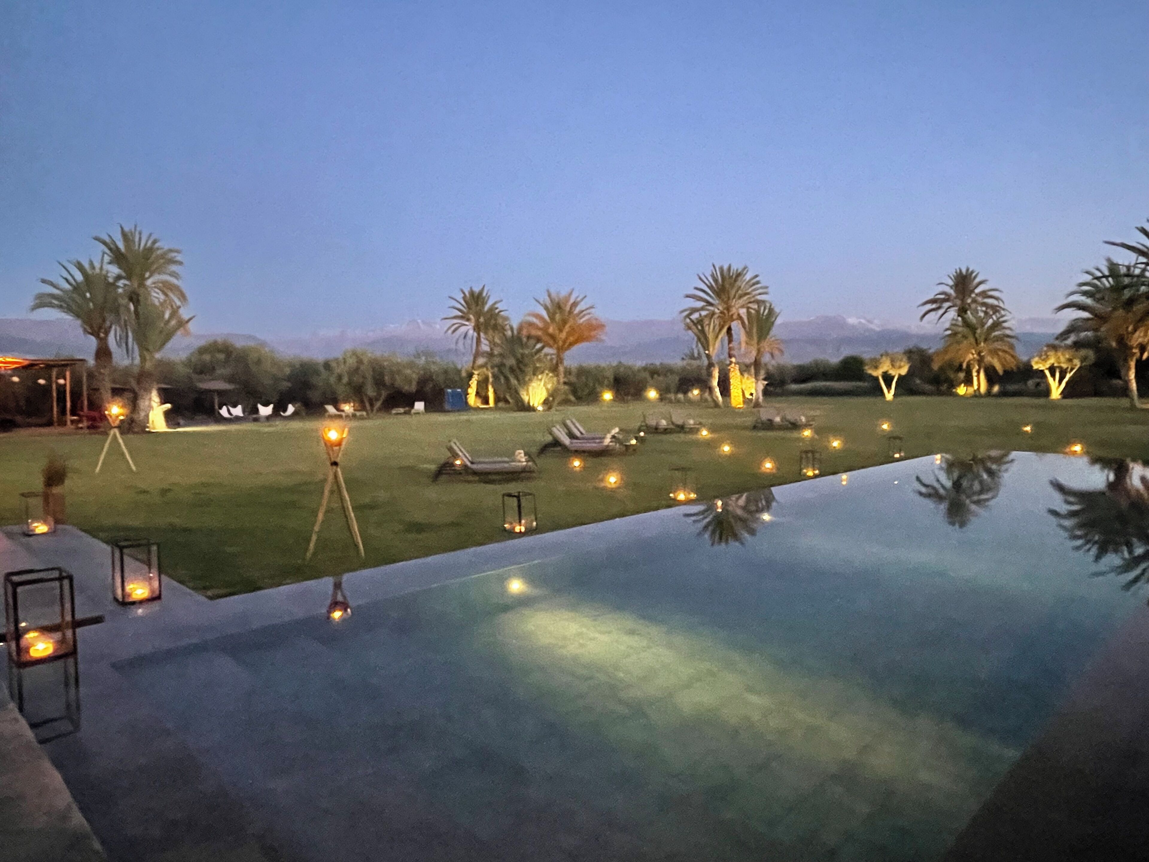 A poolside area with lounge chairs and a clear view of the mountains in the background.