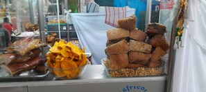 A food display with various snacks and meats, including roasted meats and fried items. - MAYTA CAPAC (Arequipa)