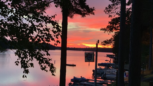 A lakeside dock with boats, a sign reading "Old Style," and trees framing the view. - Charming Cedar Lakeside Cottage at Elbert's Resort (Saint Germain)