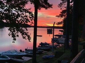 A lakeside dock with boats, a sign reading "Old Style," and trees framing the view.