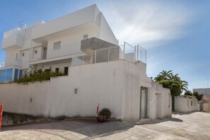 A modern multi-story building with balconies, a gated entrance, and a paved driveway. - 2306 Attico Elmar by Barbarhouse (Otranto)