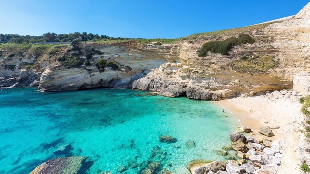 A coastal landscape with clear turquoise waters, rocky cliffs, and a sandy beach. - 2925 Casa Vacanze di Ivana- Tramontana by Barbarhouse (Santa Cesarea Terme)