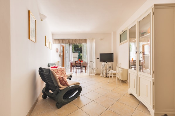 Une pièce spacieuse comprenant un coin repas, un téléviseur et un fauteuil roulant.