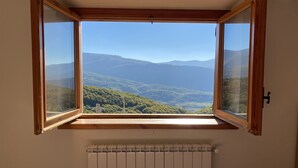 Una stanza con una grande finestra che si affaccia su un paesaggio montuoso.